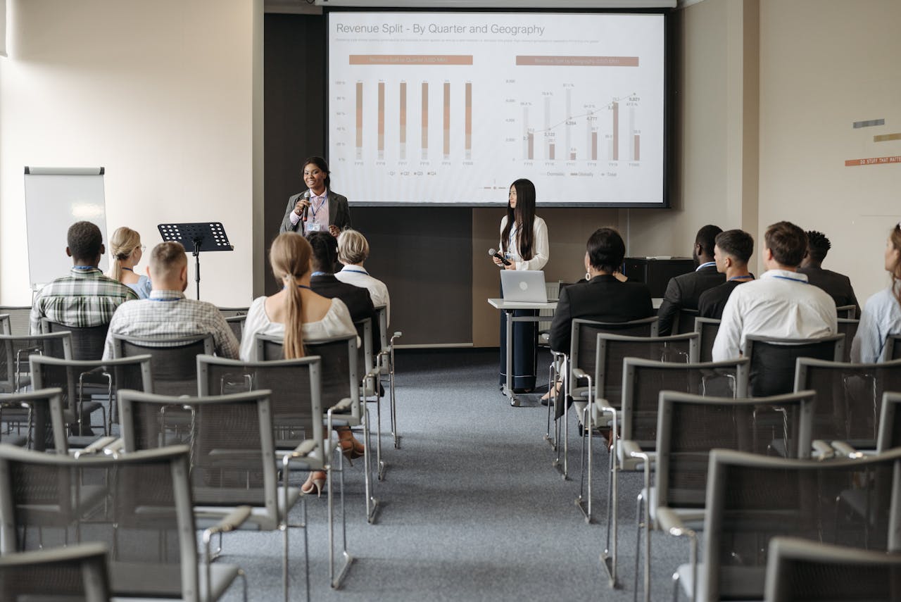 Professional business seminar with audience listening to presenters sharing data insights.